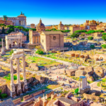 Roman Forum ruins in Rome with ancient columns and temples against a vivid blue sky.