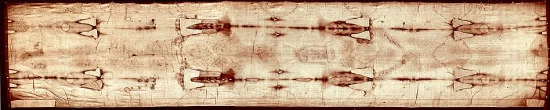 Immagine fotografica in negativo della Sindone di Torino: telo di lino di circa 4,4 metri con la doppia impronta frontale e dorsale di un corpo maschile adulto, macchie ematiche visibili in corrispondenza di mani, piedi, costato e fronte, su sfondo color seppia chiaro