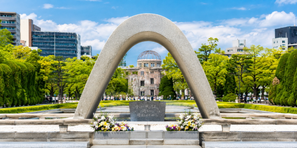Il Memoriale della Pace di Hiroshima: l'arco del Cenotafio delle vittime della bomba atomica inquadra la Cupola della Bomba Atomica (Genbaku Dome), unico edificio superstite dell'esplosione del 6 agosto 1945, oggi Patrimonio UNESCO e simbolo mondiale del disarmo nucleare