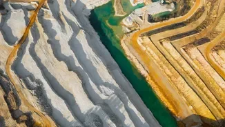 Cave Aerial view of a terraced quarry with white and beige steps beside a narrow green water channel.