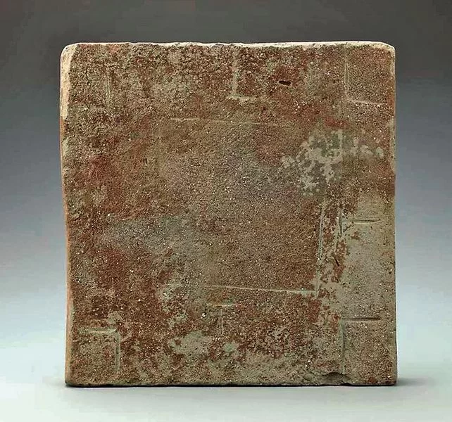 Cina Square, weathered brick tile with a rough brown surface and faint edge marks.