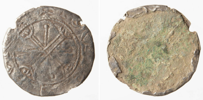 Moneta Ancient coin, obverse shows a wheel-cross design with circular inscription; reverse is heavily corroded with green patina and rough surface.