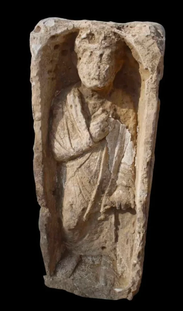 Egitto Ancient stone relief of a robed figure enclosed in a rectangular niche, head and robe weathered by time.