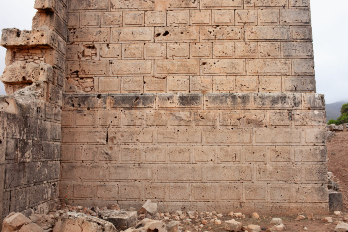 Libia Beige stone wall built from rectangular blocks with a rugged, weathered surface and rubble at the base.