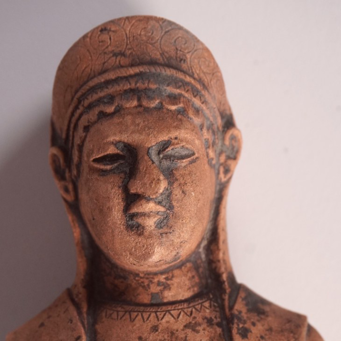 Marzabotto Terracotta bust of a person with a patterned headdress and calm, closed-eye expression.