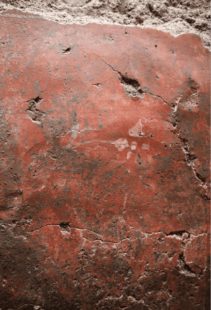 Murale romano Close-up of a weathered red brick wall with cracks and dirt bits visible on the surface.