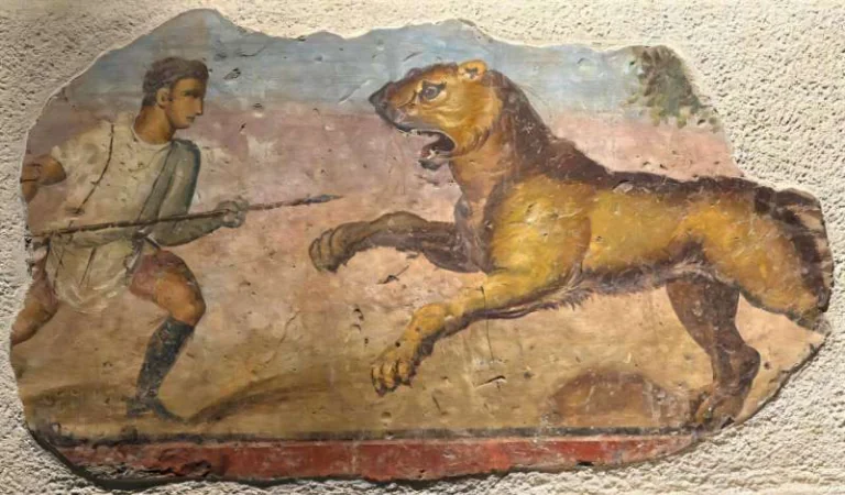 Fragment of an ancient wall painting showing a man chasing a large snarling dog with a spear bedded on a rough plaster wall.