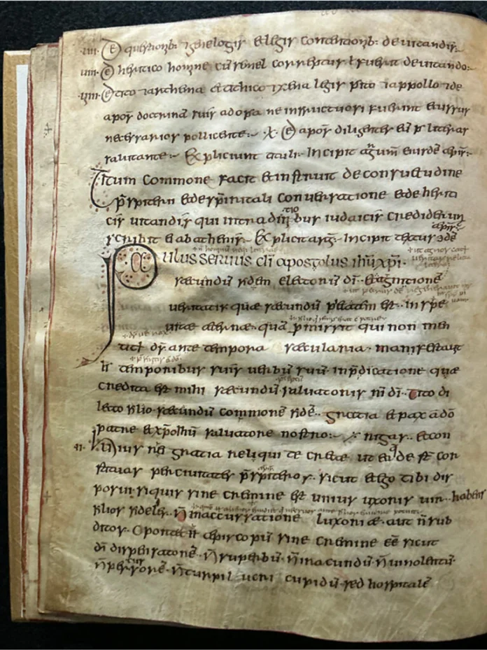 Medieval manuscript page with dense Latin writing and a large decorative initial on the left.