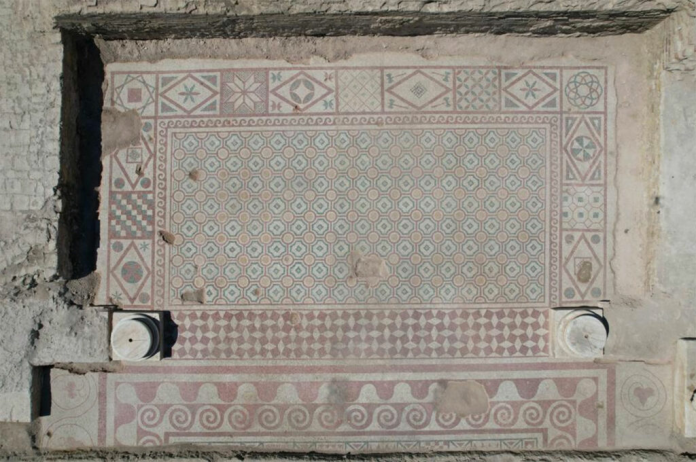 Turkey_Pompeiopolis_Mosaic_Floor Decorative ancient mosaic floor with geometric patterns and a bordered border, showing circular medallions and worn tiles.